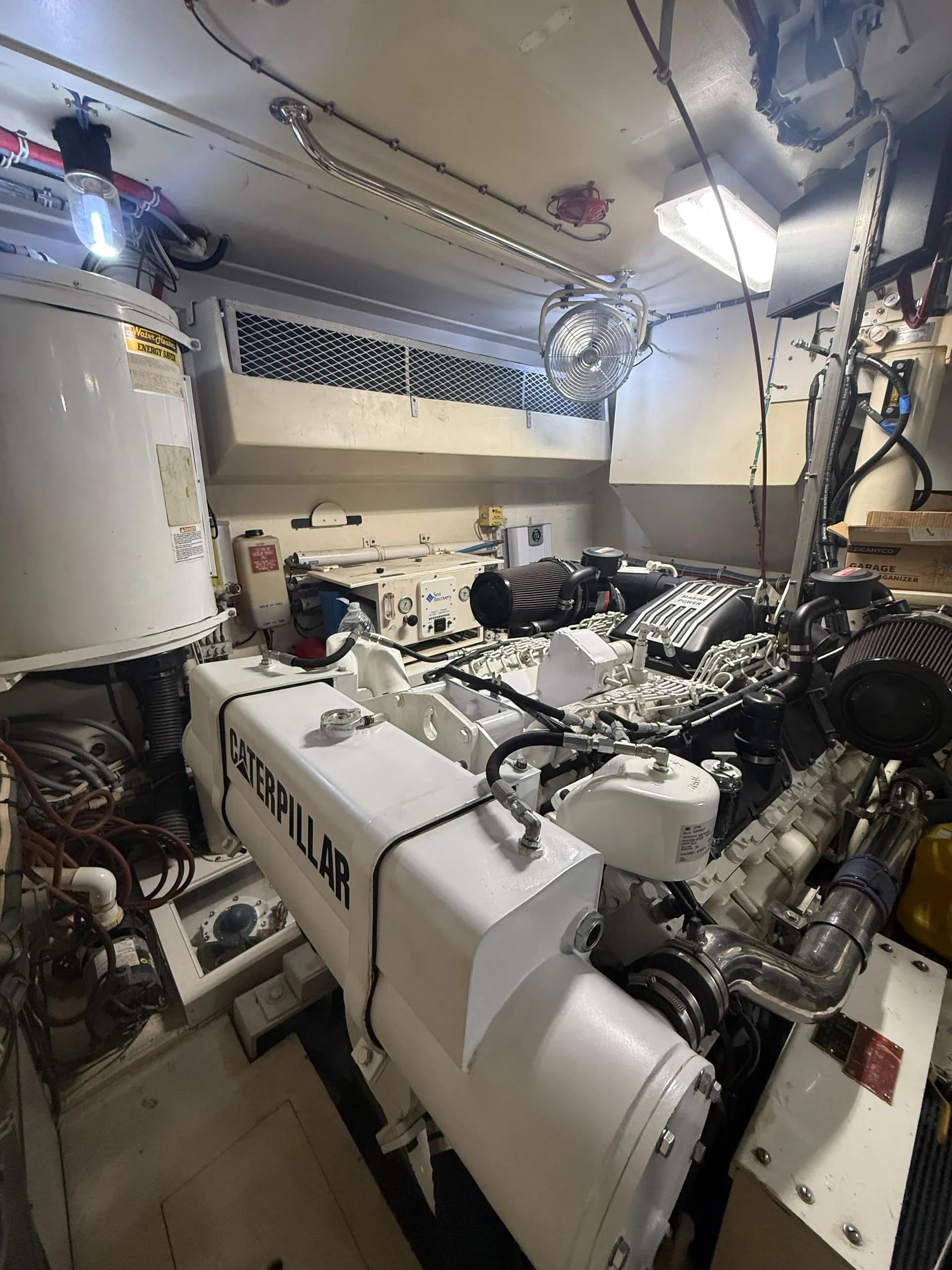 Wide view of yacht engine room showing both engines, gauges, and fire suppression systems
