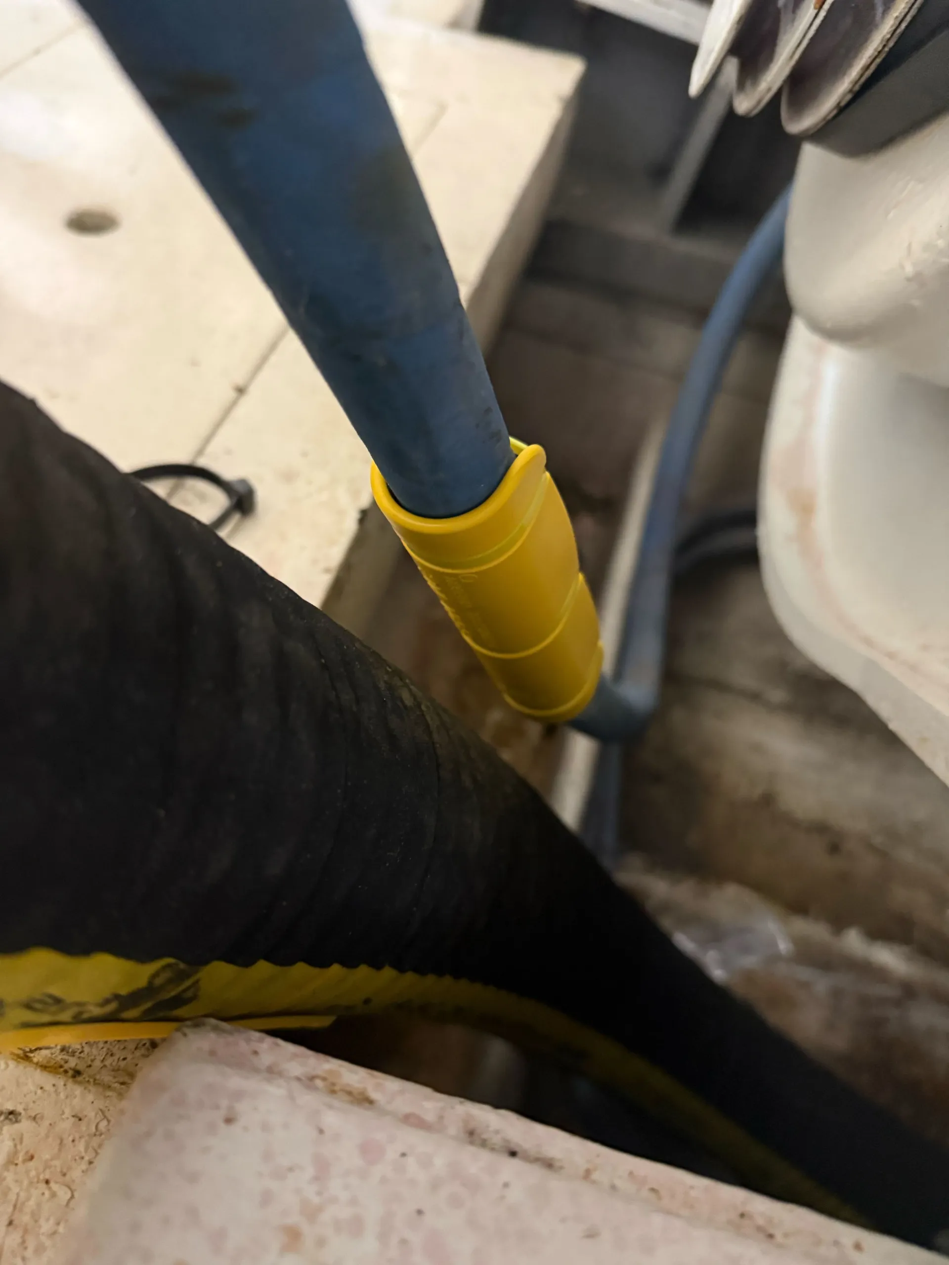 Close-up of yellow EPHA hose protector with cable tie attachment on hydraulic line