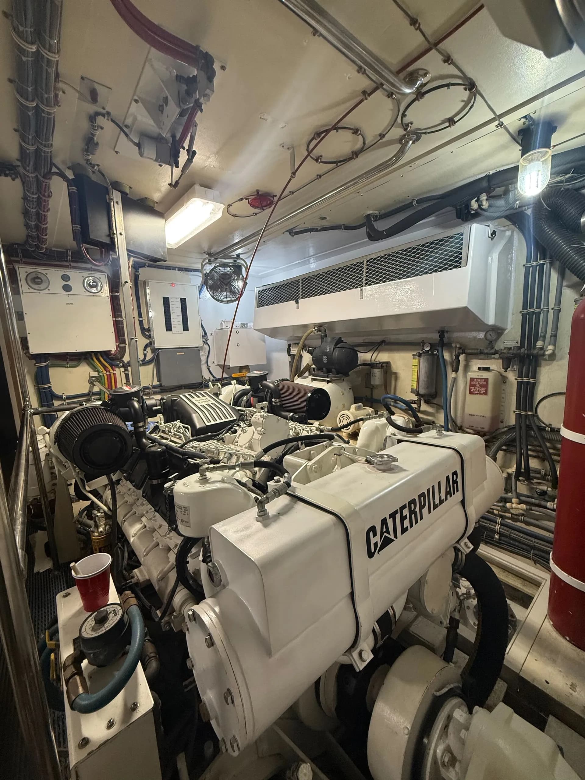 Caterpillar marine diesel engine with hydraulic hoses and electrical systems in yacht engine bay