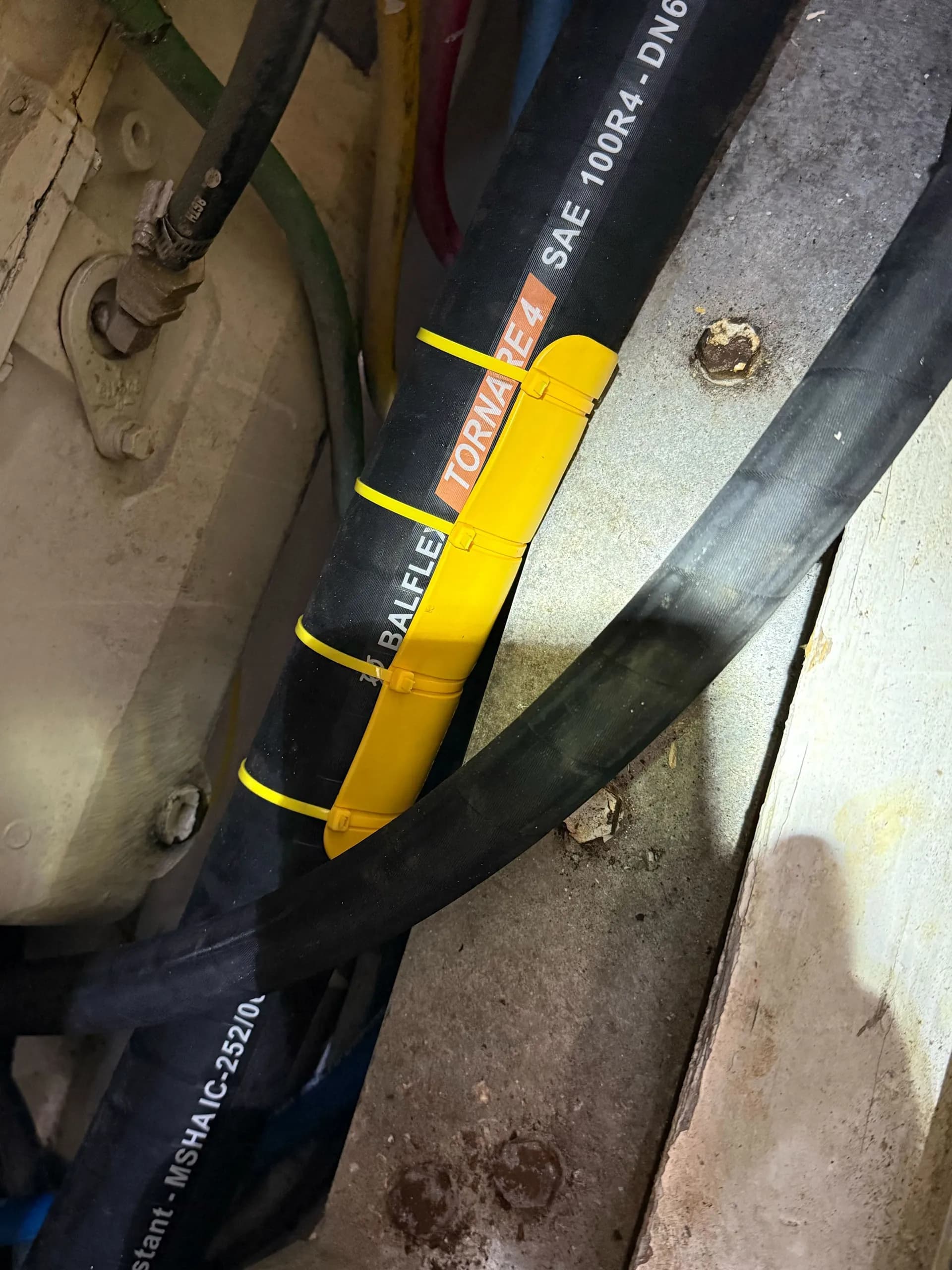 Yellow EPHA protector installed on a Balflex hydraulic hose secured with yellow cable ties